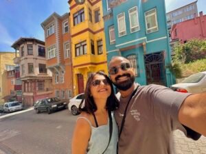 Man and Woman in front of colourful buildings