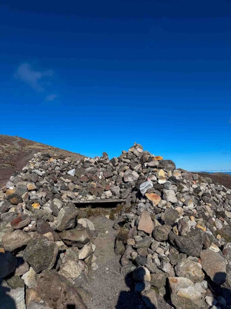 The rock tradition cairn at the summit of Mount Tarawera — thousands of rocks left by hikers overlook the ancient Maori burial ground below