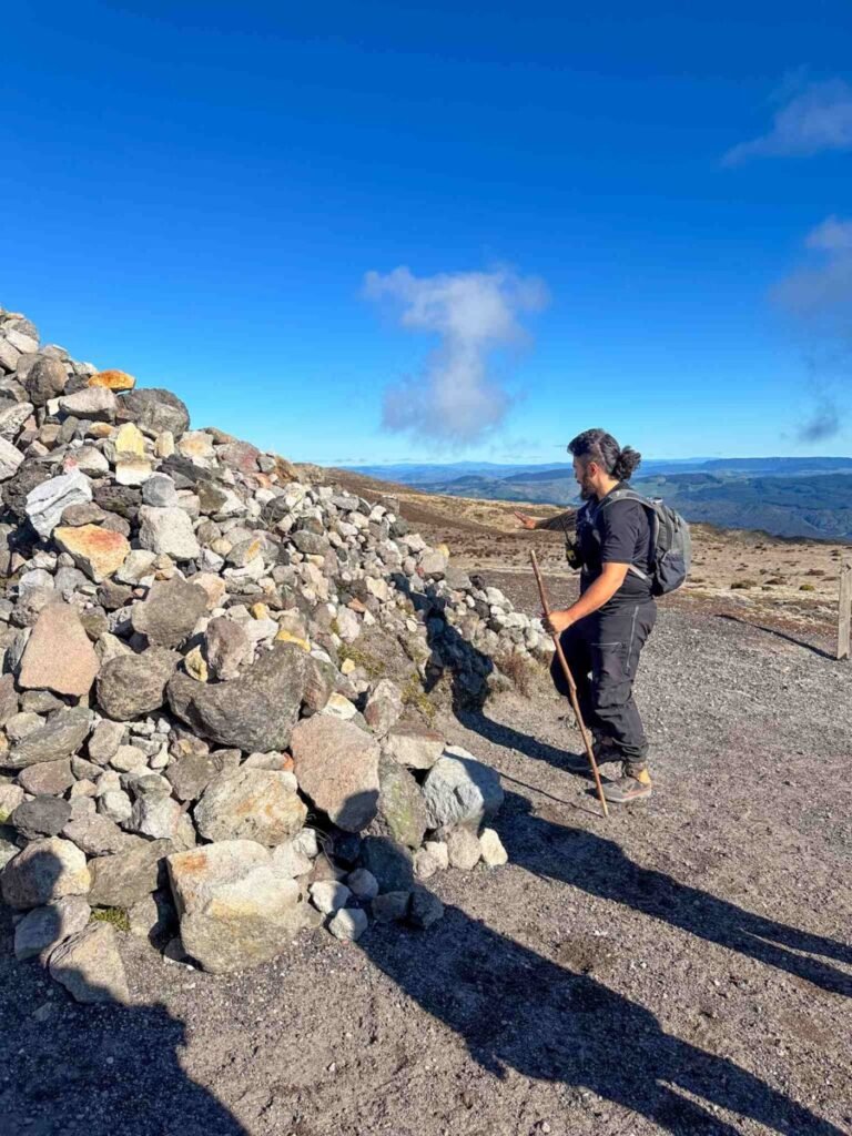 Hiker sliding down the steep volcanic scree slope during the iconic scree run descent on the Mount Tarawera guided crater walk