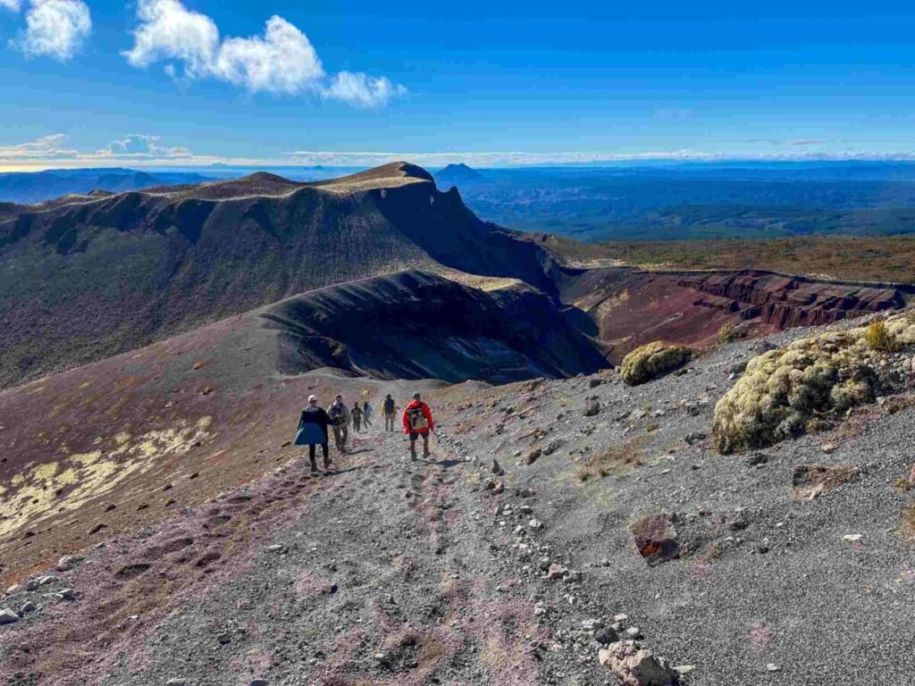 Wide view of the Mount Tarawera volcanic crater ridge showing hikers navigating the dramatic but manageable terrain on the guided crater walk