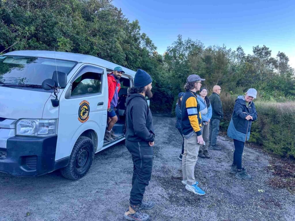 Hikers and guides preparing at the Mount Tarawera trailhead carpark before starting the Kaitiaki Adventures guided crater walk