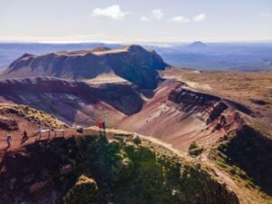 Wide aerial view of the vivid red Mount Tarawera hike volcanic crater landscape on Mount Tarawera, Rotorua New Zealand