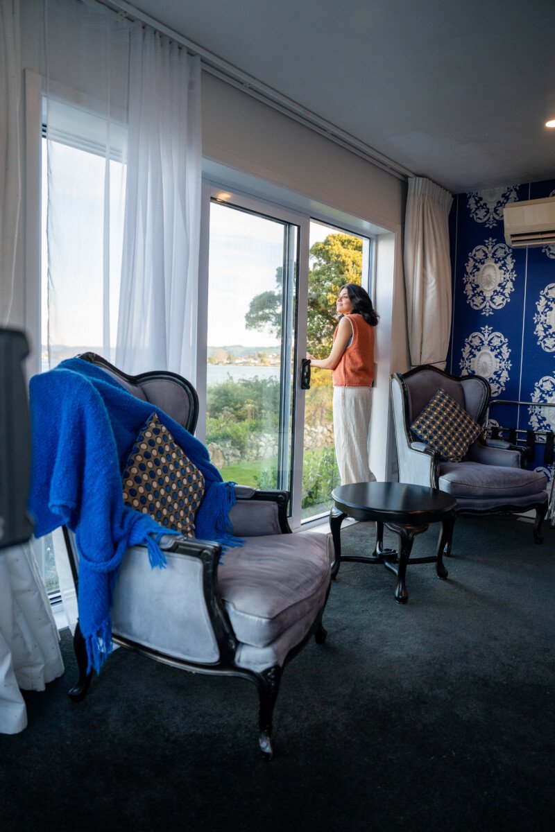 Guest enjoying lake views from a luxury Rotorua accommodation room